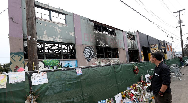 A mourner pays his respects as Investigators carry on their work at the Ghost Ship warehouse in Oakland, Calif., on December 13, 2016. A mourner pays his respects as Investigators carry on their work at the Ghost Ship warehouse in Oakland, Calif., on December 13, 2016.