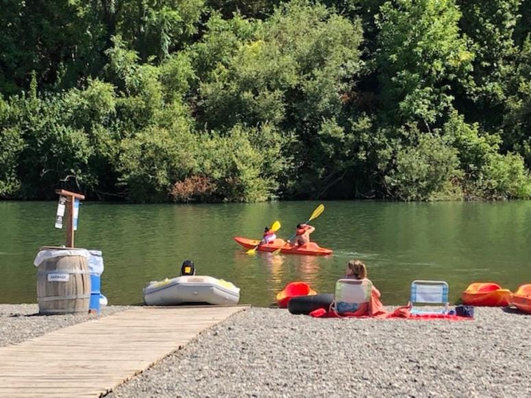 Visitors kayak in the river along Johnson's Beach in Guerneville Visitors kayak in the river along Johnson's Beach in Guerneville