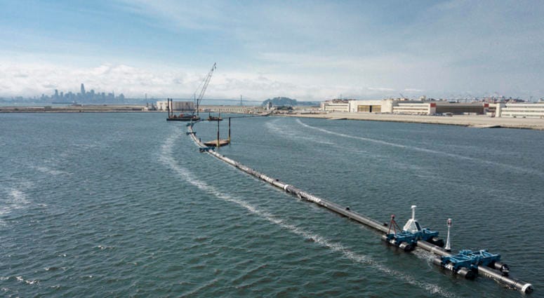 AP18250791823574 In this Monday, Aug. 27, 2018 photo provided by The Ocean Cleanup, a long floating boom that will be used to corral plastic litter in the Pacific Ocean is assembled in Alameda, Calif. Engineers will deploy a trash collection device to corral plastic litte