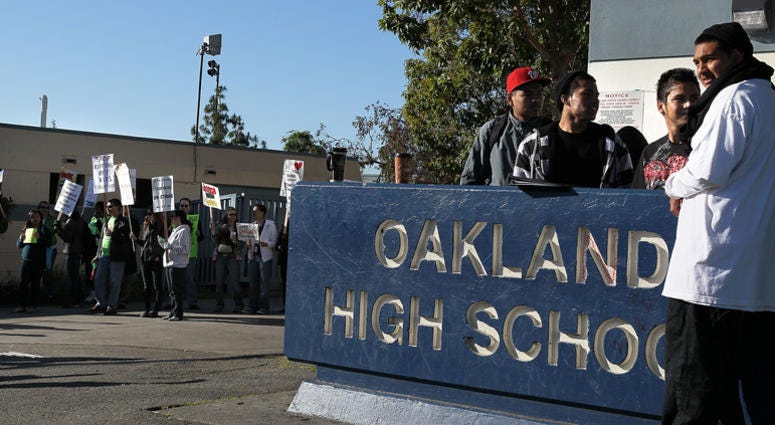 Students look on as teachers hold signs while they protest during a one-day strike outside of Oakland High School April 29, 2010 in Oakland, California. Students look on as teachers hold signs while they protest during a one-day strike outside of Oakland High School April 29, 2010 in Oakland, California.