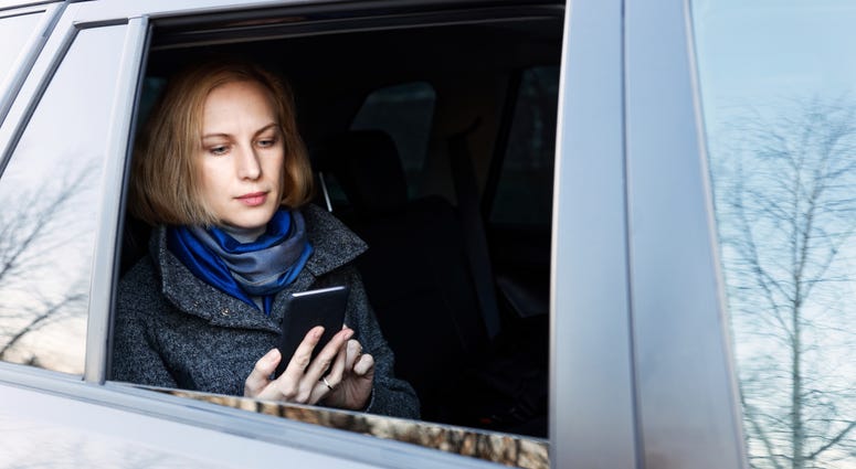 A passenger in a car summoned by an app. A passenger in a car summoned by an app.