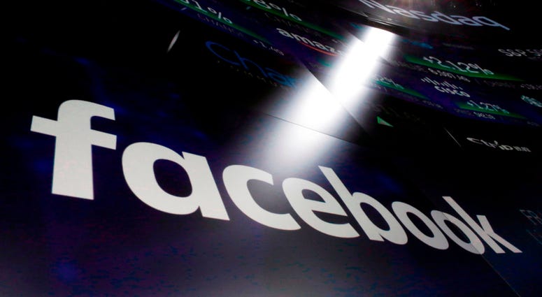In this March 29, 2018, file photo the logo for Facebook appears on screens at the Nasdaq MarketSite in New York's Times Square. Facebook says a software bug made some private posts public for as many as 14 million users for several days in May DO NOT USE