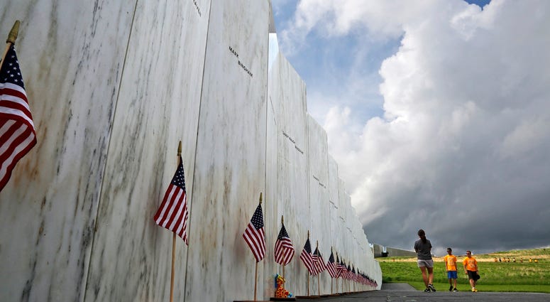 In this May 31, 2018 file photo, visitors to the Flight 93 National Memorial pause at the Wall of Names honoring 40 passengers and crew members of United Flight 93 killed when the hijacked jet crashed at the site during the 9/11 terrorist attacks