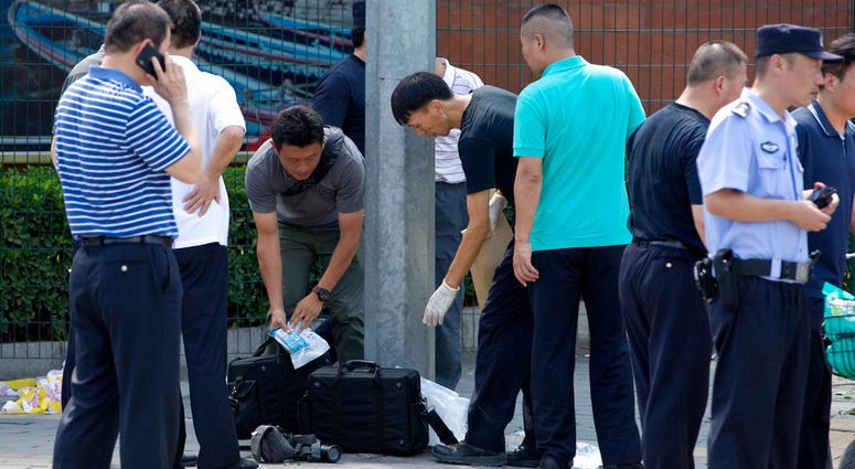 Chinese officials work near the site of a reported blast just south of the U.S. Embassy in Beijing, Thursday, July 26, 2018. DO NOT USE