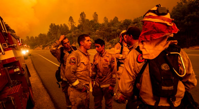 Firefighters discuss plans while battling the Carr Fire in Shasta, Calif., on Thursday, July 26, 2018. DO NOT USE
