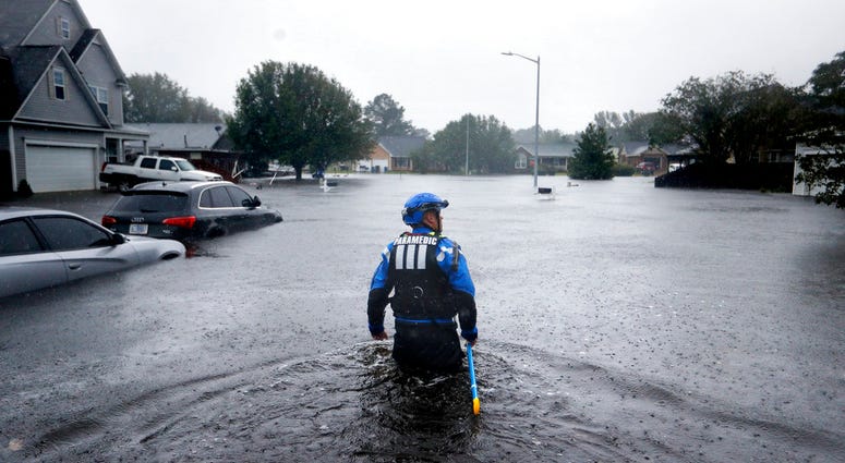 A member of the North Carolina Task Force urban search and rescue team wades through a flooded neighborhood looking for residents who stayed behind as Florence continues to dump heavy rain in Fayetteville, N.C., Sunday, Sept. 16, 2018. DO NOT USE