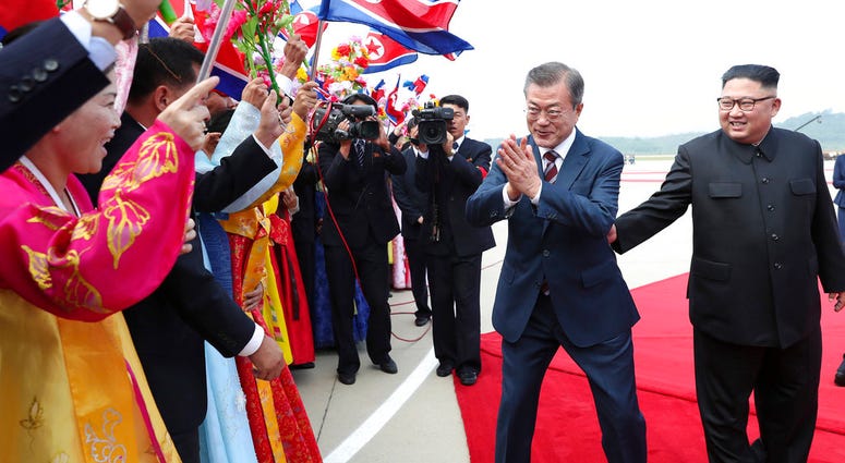 South Korean President Moon Jae-in, second from right, is greeted by North Koreans as North Korean leader Kim Jong Un, right, watches during a welcome ceremony at Sunan International Airport in Pyongyang, North Korea, Tuesday, Sept. 18, 2018. DO NOT USE