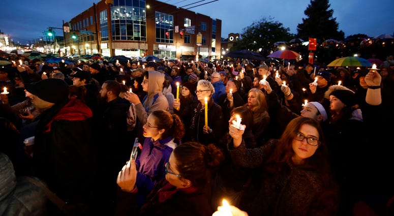 People hold candles as they gather for a vigil in the aftermath of a deadly shooting at the Tree of Life Congregation, in the Squirrel Hill People hold candles as they gather for a vigil in the aftermath of a deadly shooting at the Tree of Life Congregation, in the Squirrel Hill