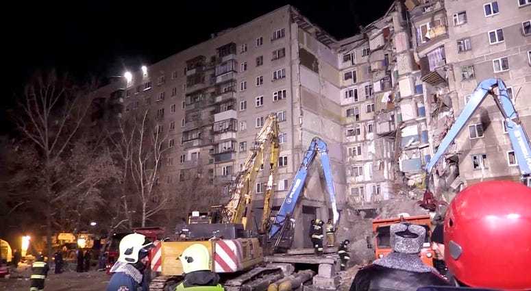 This photo provided by the Russian Emergency Situations Ministry taken from tv footage shows Emergency Situations employees work at the scene of a collapsed section of an apartment building, in Magnitigorsk, DO NOT USE