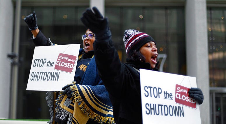 Cheryl Monroe, right, a Food and Drug Administration employee, and Bertrice Sanders, a Social Security Administration employee, rally to call for an end to the partial government shutdown in Detroit AP DO NOT USE