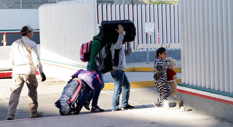 A family leaves to apply for asylum in the United States, at the border, AP DO NOT USE