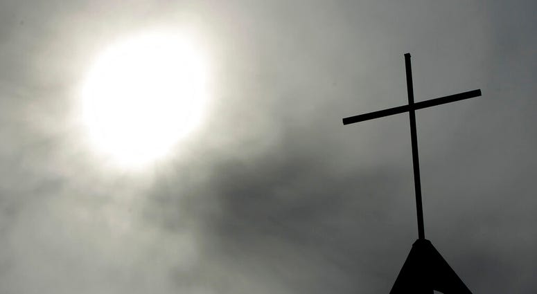 file photo a cross sits on top of a church in Berlin, Germany. AP DO NOT USE