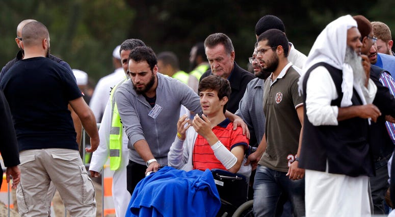 Zaed Mustafa, in wheelchair, brother of Hamza and son of Khalid Mustafa killed in the Friday March 15 mosque shootings reacts during the burial at the Memorial Park Cemetery in Christchurch, New Zealand, Wednesday, March 20, 2019. AP DO NOT USE