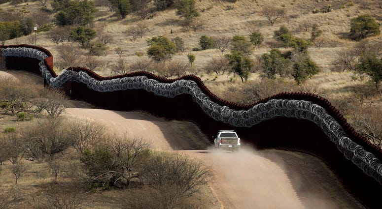 Customs and Border Control agent patrols on the US side of a razor-wire-covered border wall along the Mexico east of Nogales, Ariz Customs and Border Control agent patrols on the US side of a razor-wire-covered border wall along the Mexico east of Nogales, Ariz
