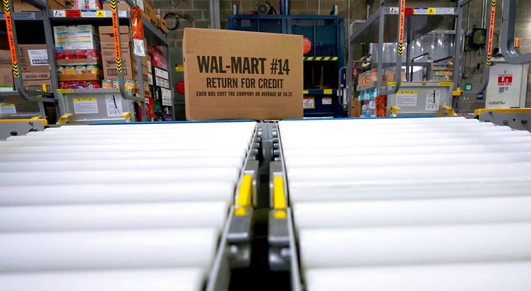 In this Nov. 9, 2018, file photo, a box of merchandise is unloaded from a truck and sent along a conveyor belt at a Walmart Supercenter in Houston. AP DO NOT USE
