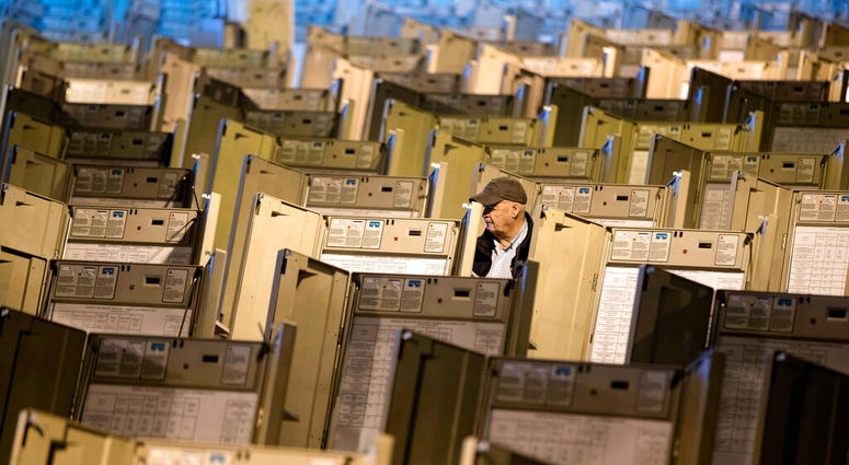 a technician works to prepare voting machines to be used in the presidential election, in Philadelphia. AP DO NOT USE