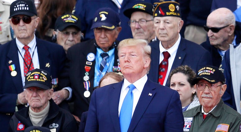President Donald Trump stands with World War II veterans during a ceremony to mark the 75th anniversary of D-Day at the Normandy American Cemetery in Colleville-sur-Mer, Normandy, France. AP DO NOT USE