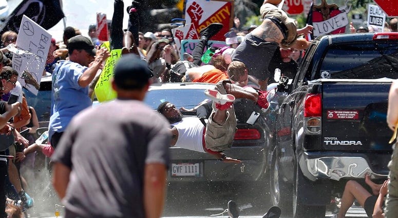 people fly into the air as a vehicle is driven into a group of protesters demonstrating against a white nationalist rally in Charlottesville, Va. AP DO NOT USE