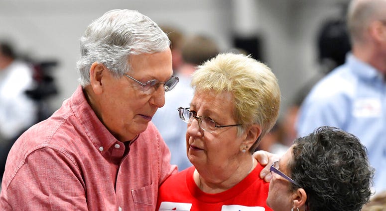 Senate Majority Leader Mitch McConnell, R-Ky., left, speaks with supporters before the start of the Graves County Republican Breakfast in Mayfield, Ky., Saturday, Aug. 3, 2019.