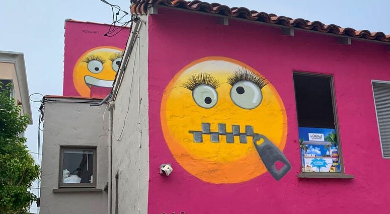 Painted emoji are seen on a house in Manhattan Beach, Calif. on Wednesday, Aug. 7, 2019. The Southern California seaside community is in an uproar after the home was given the new paint job featuring two huge emojis on a bright pink background. Manhattan