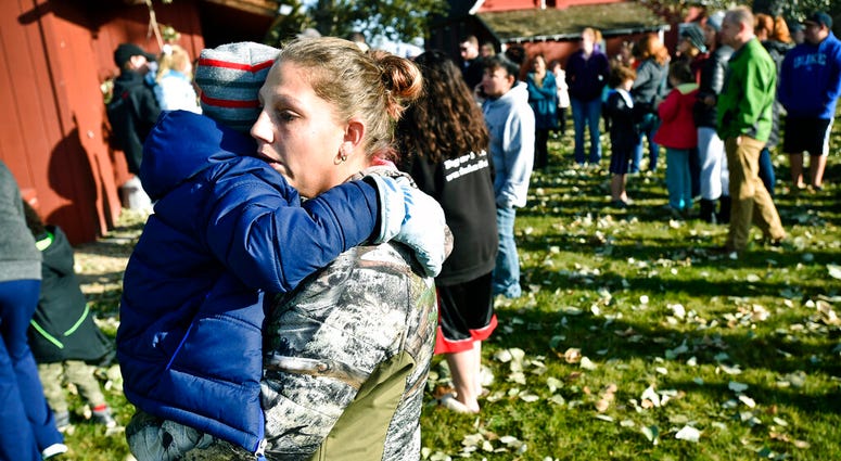 Marnie Wedgwood hugs her son after an improvised explosive device detonated on the Rossiter Elementary school playground Tuesday, Oct. 15, 2019, in Helena, Mont. Students were evacuated and then reunited with their parents at a separate location from the