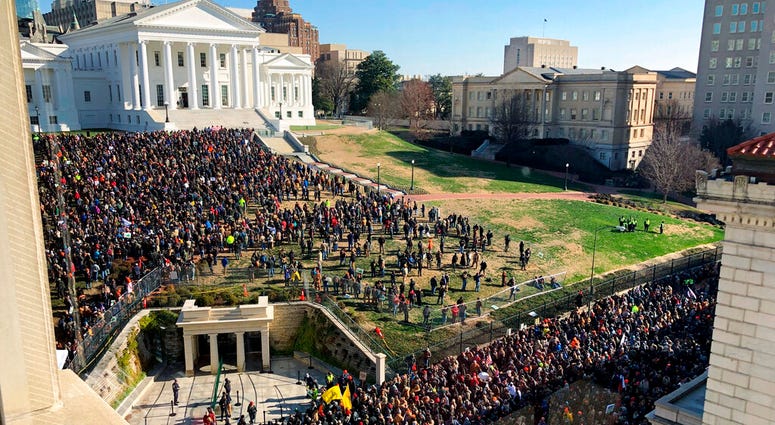 Demonstrators are seen during a pro-gun rally, Monday, Jan. 20, 2020, in Richmond, Va. Thousands of pro-gun supporters are expected at the rally to oppose gun control legislation like universal background checks that are being pushed by the newly elected