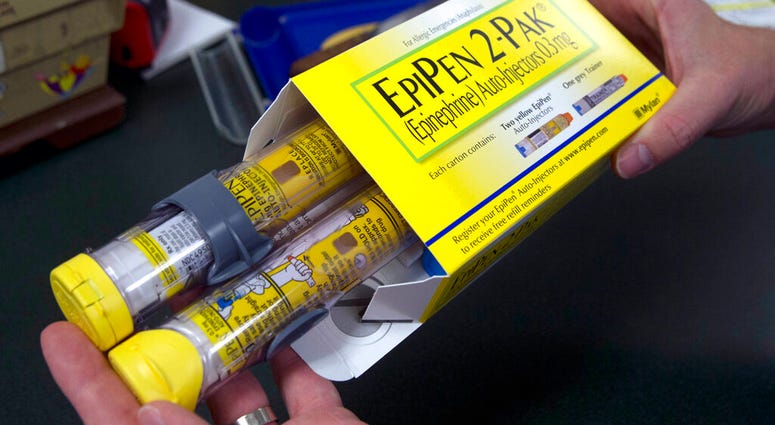 a pharmacist holds a package of EpiPens epinephrine auto-injector, a Mylan product, in Sacramento, Calif. On Tuesday, March 24, 2020, the U.S. Food and Drug Administration warned the public about malfunctions involving some EpiPens, the emergency injector