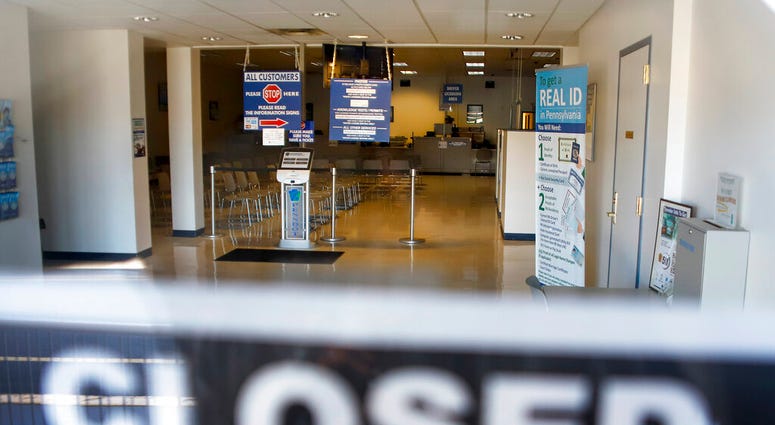 the seats and aisles are empty as seen through the window of the closed Penndot Drivers License Center in Butler, Pa.