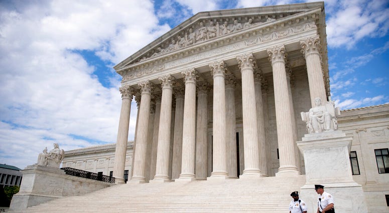 Security officers, one wearing a mask, walk in front of the Supreme Court, Thursday, May 14, 2020, in Washington. (AP Photo/Andrew Harnik)