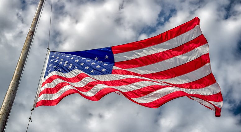American flag at half-staff blowing in wind American flag at half-staff blowing in wind