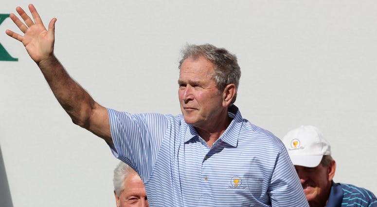 George W. Bush waves to the crowd prior to Thursday foursome matches of the Presidents Cup DO NOT USE