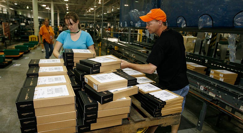 JUNE 10: Amazon employees Heather Redman, (L) and Troy Scott pack the new Kindle DX, Amazon's 9.7" Wireless Reading Device for shipment at the warehouse on June 10, 2009