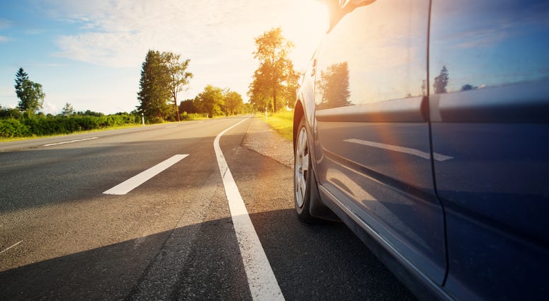 Car on asphalt road on summer day at park Car on asphalt road on summer day at park