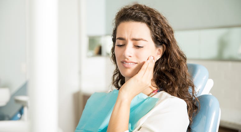 Young Woman Suffering From Toothache In Dental Clinic Young Woman Suffering From Toothache In Dental Clinic