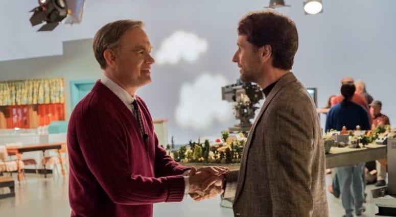 Tom Hanks (as Mr. Rogers) shaking hands with Matthew Rhys (as Tom Junod)