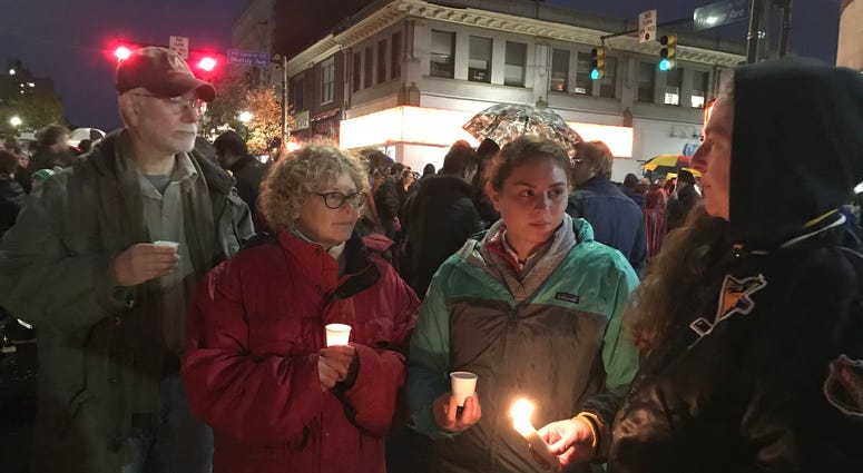 Anne-Marie Silver, left, Mara Silver and Beth Silver, all members of Congregation Dor Hadash Synagogue, attend a candle-light vigil in the Squirrel Hill neighborhood of Pittsburgh.