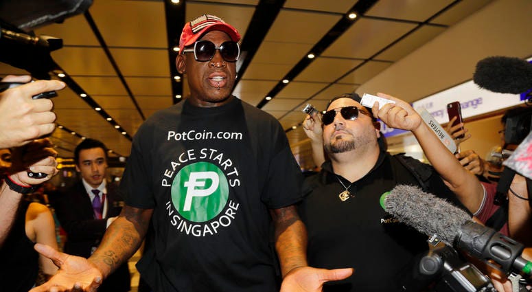 Former NBA basketball player Dennis Rodman, and Chris Volo, right, arrive at Singapore's Changi Airport DO NOT USE