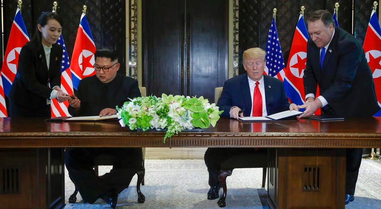orth Korea leader Kim Jong Un and U.S. President Donald Trump prepare to sign a document at the Capella resort on Sentosa Island Tuesday DO NOT USE