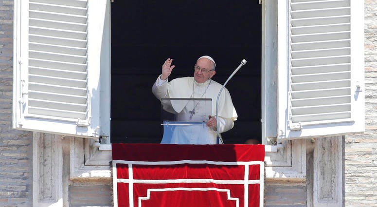 Pope Francis blesses the crowd as he recites the Angelus noon prayer from the window of his studio overlooking St.Peter's Square, at the Vatican, DO NOT USE