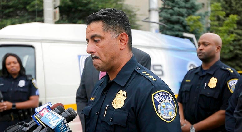 Milwaukee Police Chief Alfonso Morales holds back tears as he speaks to the media as authorities investigate the scene where a police officer was fatally shot, Wednesday, July 25, 2018, in Milwaukee. A suspect is in custody. DO NOT USE