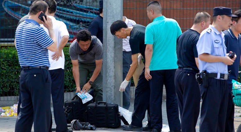 Chinese officials work near the site of a reported blast just south of the U.S. Embassy in Beijing, Thursday, July 26, 2018. DO NOT USE