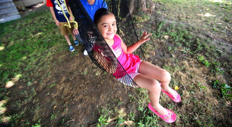 Adalene Moreno plays in a swing Wednesday, Aug. 1, 2018, in Sandy, Utah. Adalene, a 4-year-old Utah girl who had two fingers partially amputated in a grocery store escalator last year is learning to color pictures again, DO NOT USE
