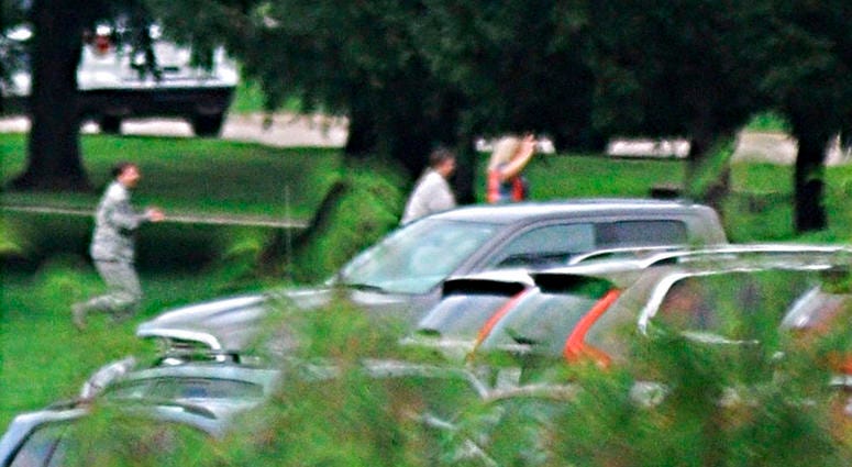 People run with their hands up amid reports of an active shooter at Wright-Patterson Air Force base in Ohio on Thursday, Aug. 2, 2018. DO NOT USE