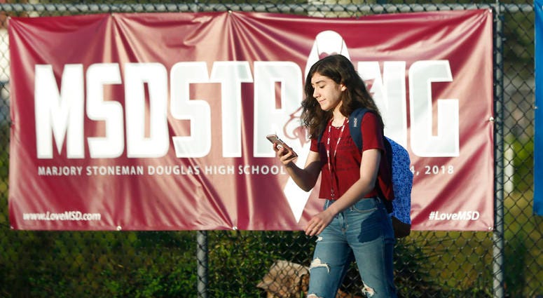 A student walks past an "MSDSTRONG" banner on the way to class at Marjory Stoneman Douglas High School, Wednesday, Aug. 15 DO NOT USE