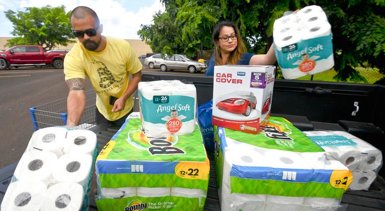 Bryce and Dom Boeder of Waimea, Kauai, load their truck with storm supplies in the parking lot of a Walmart store in Lihue, on the island of Kauai, Hawaii, Tuesday, Aug. 21, 2018.