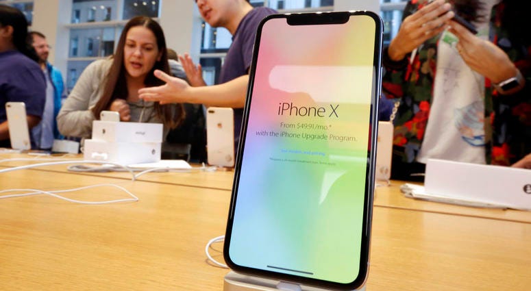 n this Nov. 3, 2017, file photo, customers buy the iPhone X at the Apple Store DO NOT USE