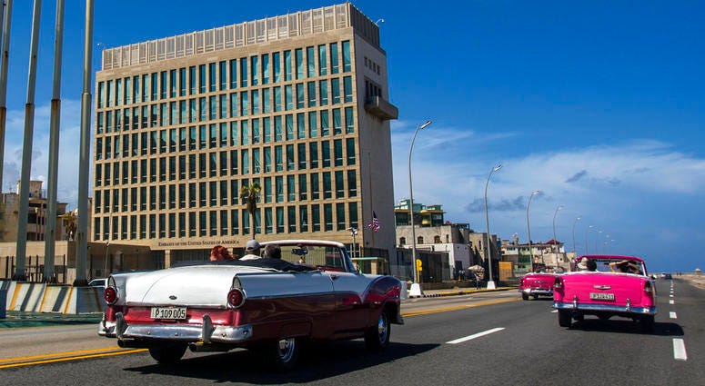 In this Oct. 3, 2017, file photo, tourists ride classic convertible cars on the Malecon beside the United States Embassy in Havana, Cuba. DO NOT USE