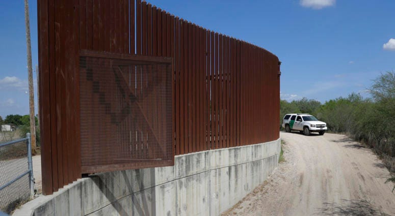 a U.S. Customs and Border Patrol vehicle passes along a section of border levee wall in Hidalgo, Texas. AP DO NOT USE
