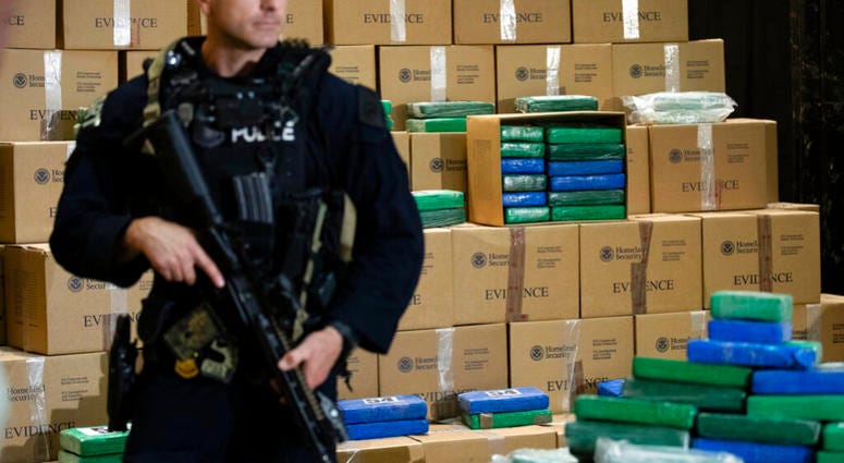 An officer stand guard over a fraction of the cocaine seized from a ship at a Philadelphia port that was displayed at a news conference at the U.S. Custom House in Philadelphia, Friday, June 21, 2019. AP DO NOT USE