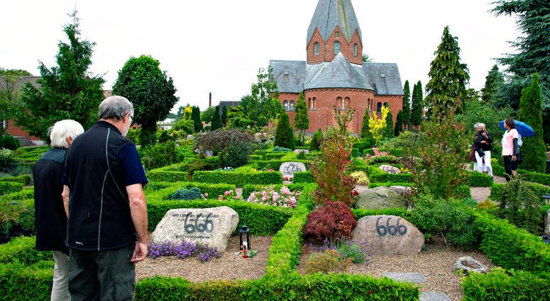 People look at a vandalised tombstone at Hadsund Cemetery, in eastern Jutland, Denmark AP DO NOT USE